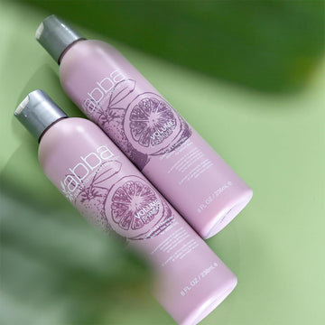 ABBA Volume Shampoo and Volume Conditioner 8 oz bottles displayed on a green background