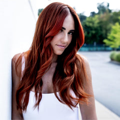 Model with long layered brunette hair colored a rich multidimensional copper shade.