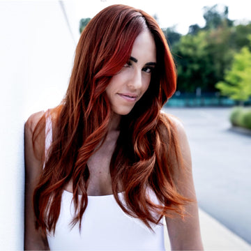 Model with long layered brunette hair colored a rich multidimensional copper shade.