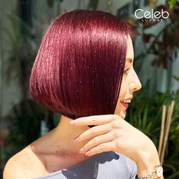 Model with a sleek chin-length bob showing a glossy deep red-burgundy brunette hair color result.