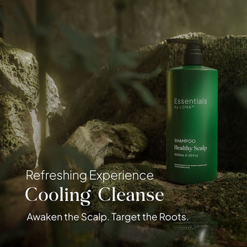 Essentials by LOMA Healthy Scalp Shampoo 33 oz pump bottle displayed among moss and rocks with cooling cleanse and scalp-care messaging