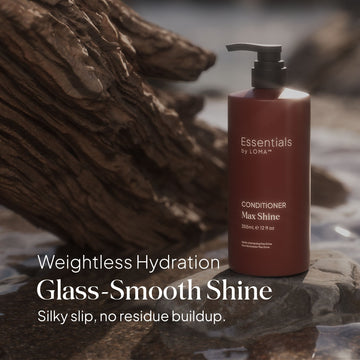 Essentials by LOMA Max Shine Conditioner 12 oz pump bottle displayed on rocks with weightless hydration, glass-smooth shine, and silky slip messaging