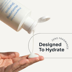 Loma Fragrance Free Moisturizing Shampoo flowing from an open white bottle onto a hand, highlighting zero fragrance and hydration