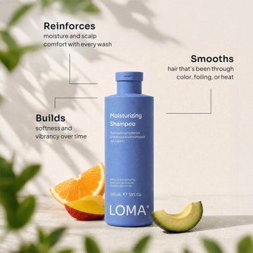 Loma Moisturizing Shampoo bottle surrounded by mango and orange slices with text highlighting moisture, scalp comfort, softness, and vibrancy