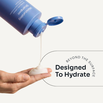 Loma Moisturizing Shampoo dispensed from an open blue tube onto a hand, demonstrating its creamy texture