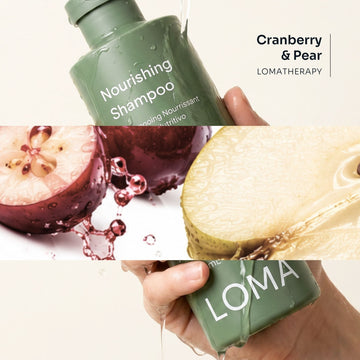 Loma Nourishing Shampoo held in wet hands beside cranberry and pear imagery, highlighting the Cranberry and Pear LomaTherapy blend