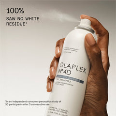 OLAPLEX Nº.4D Clean Volume Detox Dry Shampoo can being sprayed with a claim of no visible white residue