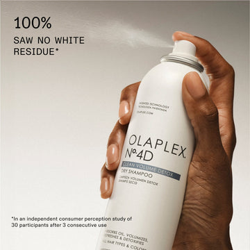 OLAPLEX Nº.4D Clean Volume Detox Dry Shampoo can being sprayed with a claim of no visible white residue