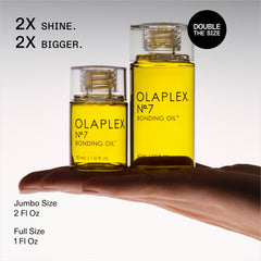 OLAPLEX Nº.7 Bonding Oil size comparison showing 1 oz full-size and 2 oz jumbo bottles on a hand