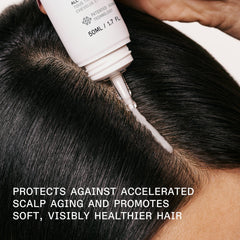 OLAPLEX Scalp Longevity Treatment applicator being used along a scalp part to apply the treatment to dark hair