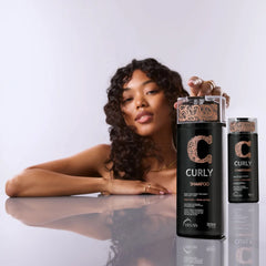 Model with defined dark curls beside TRUSS Professional Curly Shampoo and Conditioner bottles