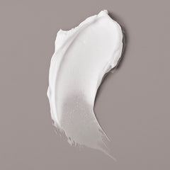 White Verb Forming Fiber styling product texture smeared on a gray background
