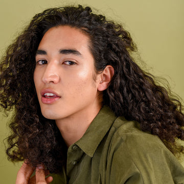 Close-up of a model with long dark curly hair in a Verb Sculpting Clay styling campaign
